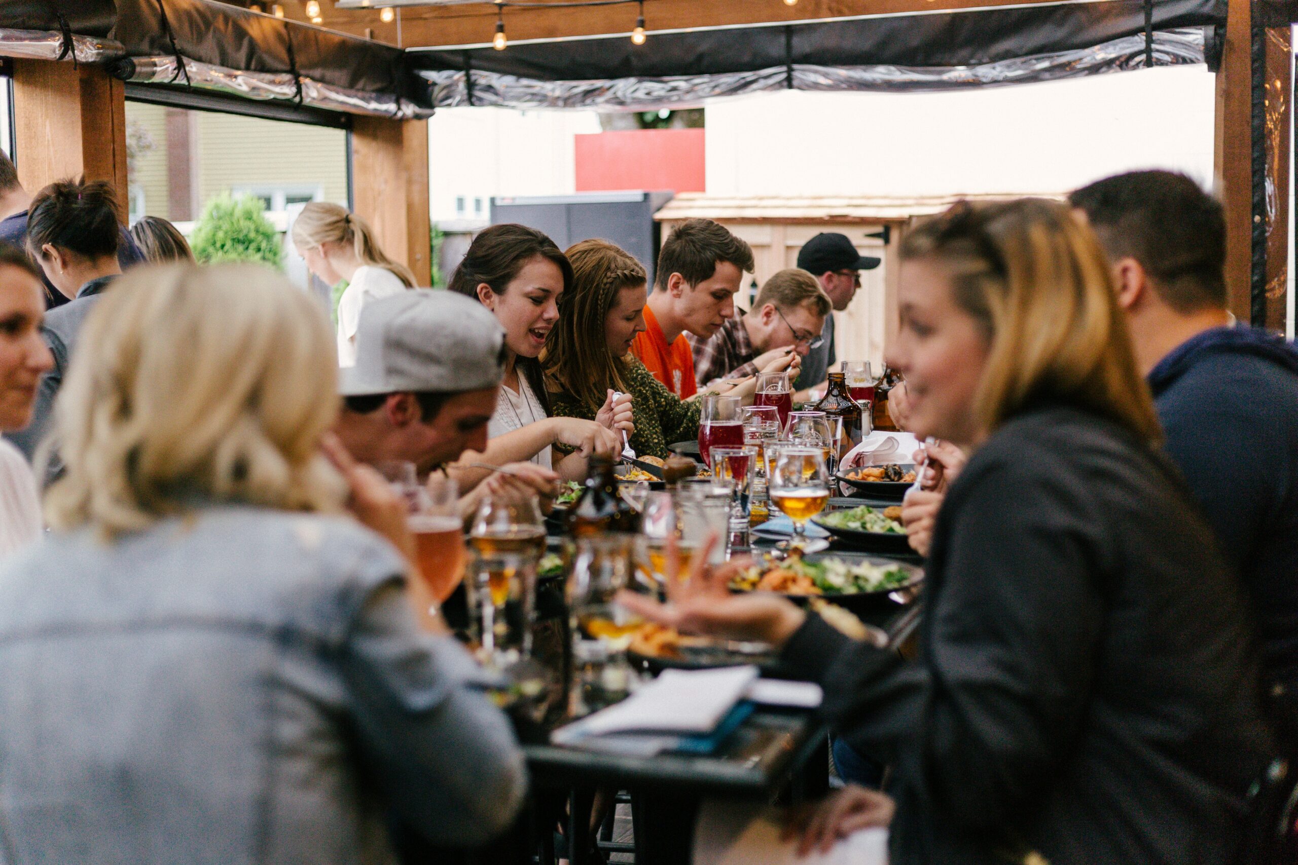 People eating a meal around a table. Photo by Priscilla Du Preez 🇨🇦 on Unsplash.